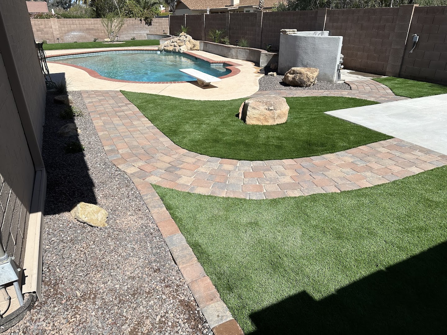Pool with turf and boulder landscaping, West Valley AZ